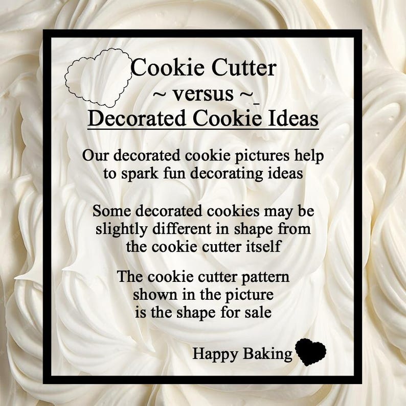 May include: A black framed sign with the text "Cookie Cutter ~ versus ~ Decorated Cookie Ideas". The sign is on a white background with a heart-shaped outline and a black heart. The text explains the difference between cookie cutters and decorated cookies.