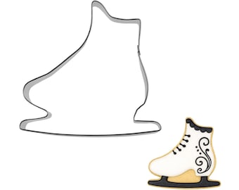 May include: A metal ice skate cookie cutter next to a decorated ice skate cookie. The cookie cutter is a simple outline of an ice skate. The decorated cookie is white with black laces and a black and gold base.