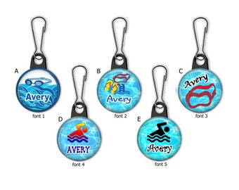 May include: Five different zipper pulls with a blue and white swimming pool design. Each pull features a different swimming-related icon and the name Avery in a different font. The icons include goggles, flip flops, a diving board, a swimmer, and a pair of goggles.
