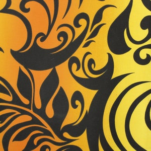 May include: A yellow and orange fabric with a black floral pattern. The fabric has a gradient from orange to yellow. The pattern is made up of swirls and leaves.