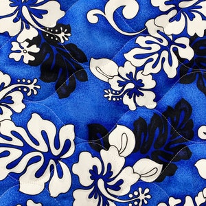 May include: Blue fabric with a white and black floral pattern. The pattern features hibiscus flowers and leaves.
