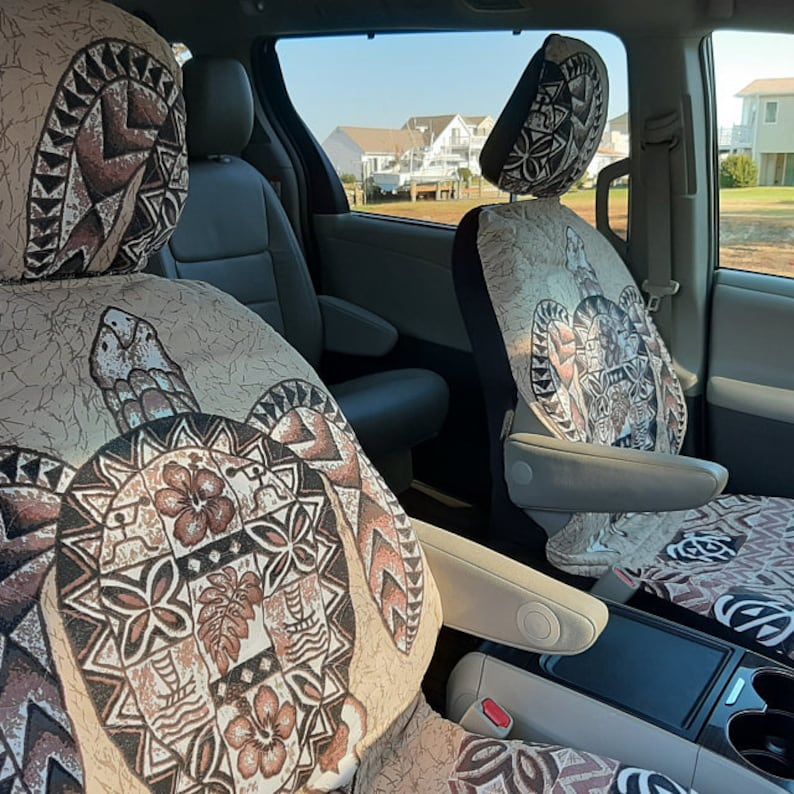 May include: Two car seat covers with a beige background and a brown turtle design. The turtle design features a floral pattern and geometric shapes.