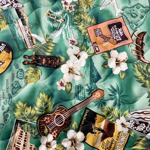 May include: A green quilted fabric with a Hawaiian theme. The fabric features images of palm trees, surfboards, ukuleles, and the text "HAWAIIAN UKULELE".