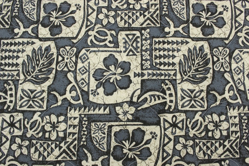 May include: A black and white patterned fabric with a Hawaiian theme. The pattern includes hibiscus flowers, leaves, and geometric shapes. The fabric has a distressed look, as if it has been worn and faded.