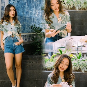 Pu&ograve; includere: Una donna indossa una camicia abbottonata a fiori blu e bianca a maniche corte e pantaloncini di jeans. &Egrave; in piedi davanti a un muro piastrellato e tiene un telefono.