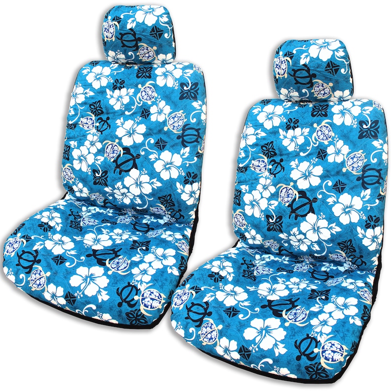 May include: Two blue and white car seat covers with a tropical floral pattern featuring hibiscus flowers and sea turtles. The covers have a black trim and a matching headrest.