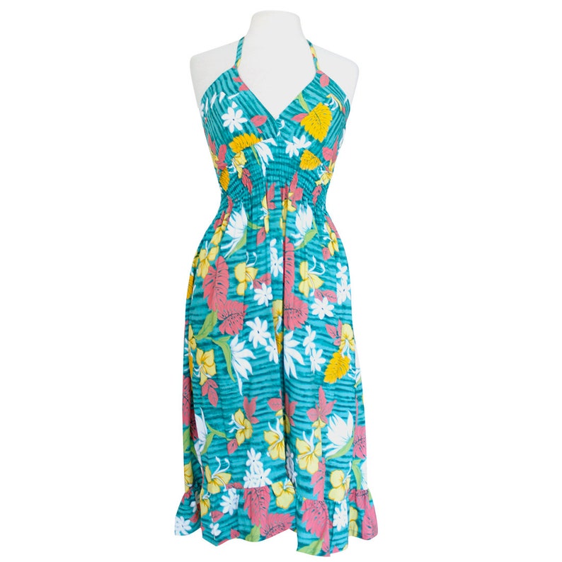 May include: A teal blue halter dress with a floral print featuring pink, yellow, and white flowers. The dress has a gathered waist and a ruffled hem.