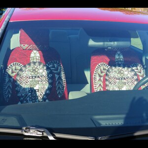 May include: Two red car seat covers with a green and white turtle design. The covers are made of a soft, comfortable fabric and feature a Hawaiian-inspired pattern.