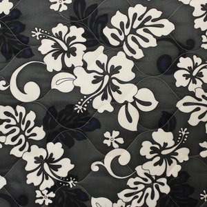 May include: Black and white floral fabric with a repeating pattern of hibiscus flowers. The fabric has a quilted texture.