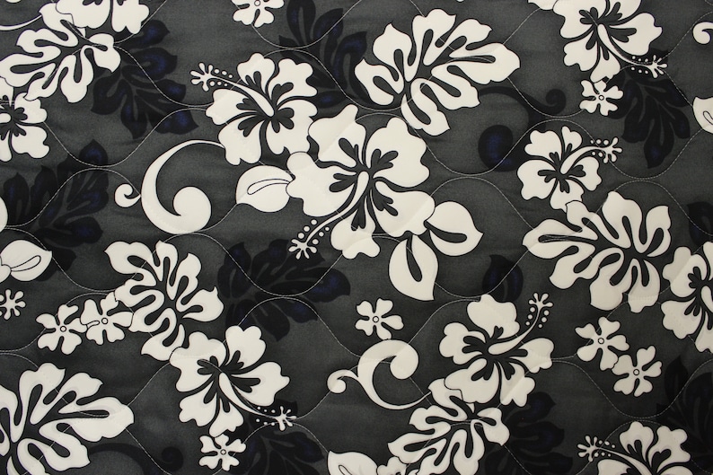 May include: Black and white floral fabric with a repeating pattern of hibiscus flowers. The fabric has a quilted texture.