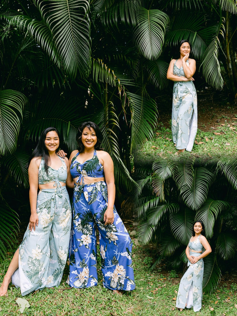 Pu&ograve; includere: Due persone che indossano pantaloni e top abbinati con stampa floreale blu e bianca. I pantaloni hanno una gamba larga e i top hanno un nodo sul davanti. Le persone sono in piedi davanti a uno sfondo tropicale verde lussureggiante.