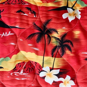 May include: Red fabric with a quilted pattern featuring a tropical sunset scene with palm trees, white flowers, and the word "Aloha".