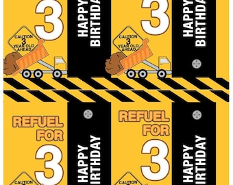 May include: Four yellow and black construction themed birthday party favor tags with the text "Refuel for 3" and "Happy Birthday". Each tag features a cartoon dump truck with a "Caution 3 Year Old Ahead" sign.