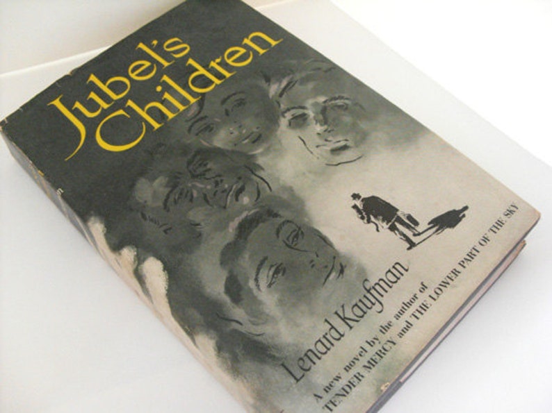 May include: A vintage book titled "Jubel's Children" by Lenard Kaufman. The cover has a dark background with yellow lettering and illustrations of faces. A silhouette of a person is also visible.