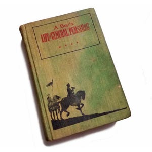 May include: A green book titled "A Boy's Life of General Pershing" with a black silhouette of three men on horseback on the cover.