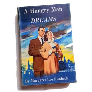 May include: A vintage paperback book cover with a blue background and a couple standing in front of a cityscape. The title is "A Hungry Man DREAMS" by Margaret Lee Runbeck.