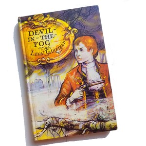 May include: A vintage paperback book cover with a yellow and orange illustration of a young man holding a pistol. The title of the book is "Devil in the Fog" by Leon Garfield.