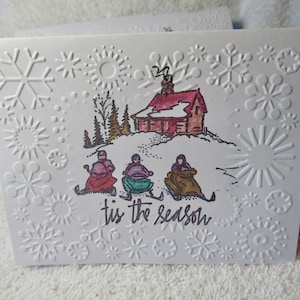 Zestaw kart zimowych zawiera skutery śnieżne, tłoczoną kartę, kartę świąteczną, kartę „Tis the season”, 10 kart z kopertami, puste wnętrze, kartę ze znaczkiem