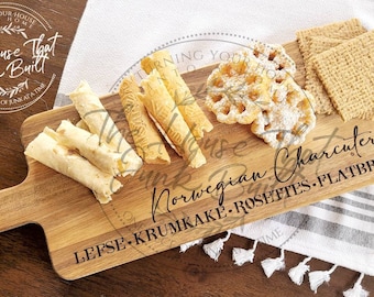 Puede incluir: Una tabla de servir de madera con asa, con el texto "The House That Junk Built" y "Norwegian Charcuterie Lefse-Krumkake-Rosettes-Flatbread". La tabla está llena de varios pasteles noruegos, incluyendo lefse, krumkake y rosettas.