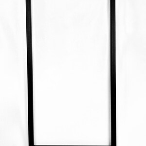 Puede incluir: Patas de mesa de metal negro con un marco rectangular y una sola barra transversal. Las patas tienen una base cuadrada.