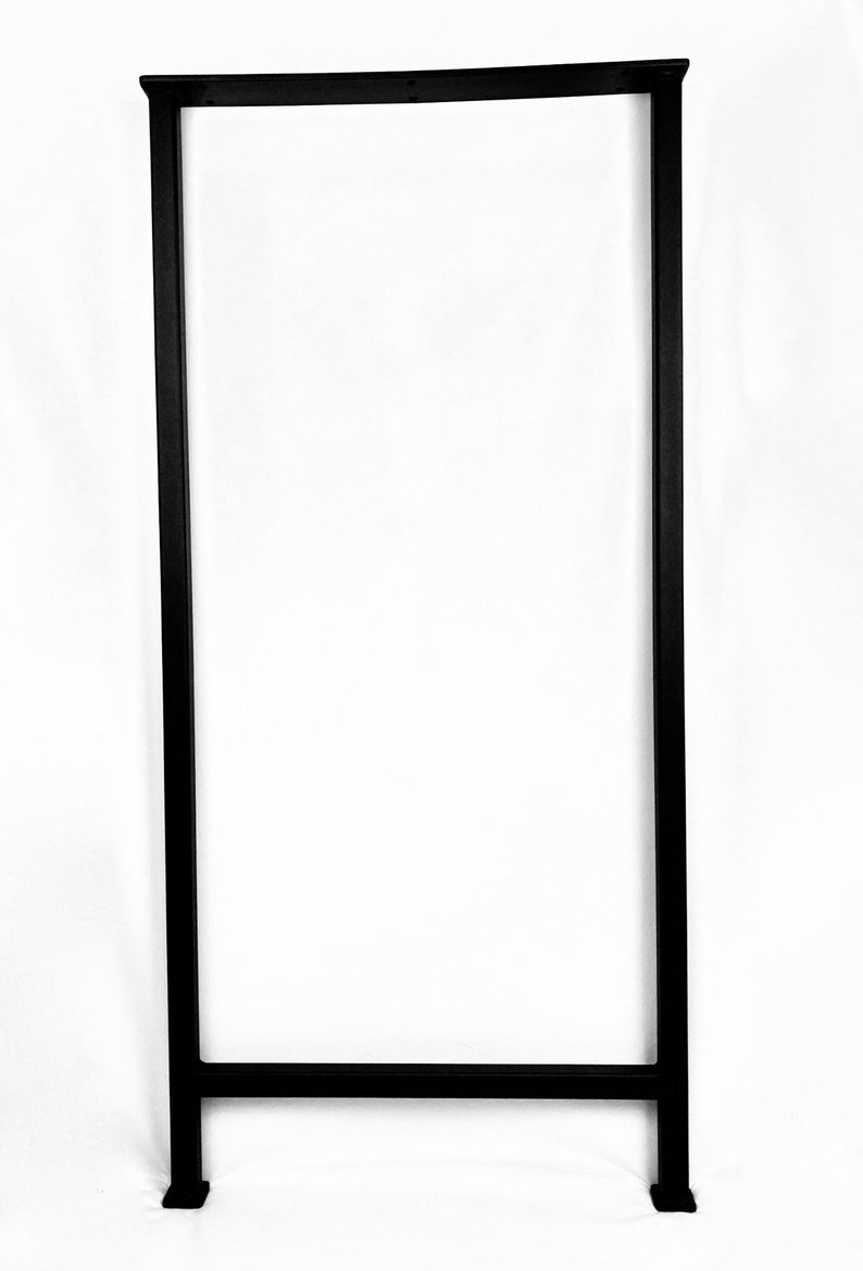 Puede incluir: Patas de mesa de metal negro con un marco rectangular y una sola barra transversal. Las patas tienen una base cuadrada.