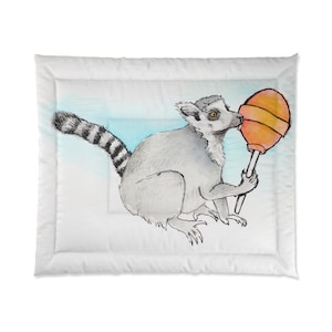 Può includere: Un piumino con un'illustrazione disegnata a mano di un lemure che tiene in mano un grande lecca-lecca arancione. Il lemure è grigio con una coda a strisce, su uno sfondo azzurro e bianco.