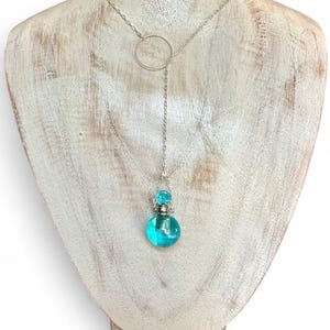 Aqua Aura essential oil, ash urn pendulum Y necklace, sterling chain & ring centerpiece.