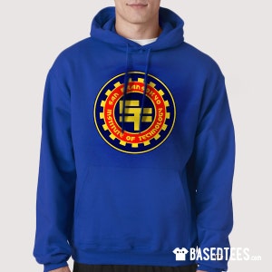 Puede incluir: Una sudadera con capucha azul real con un logotipo amarillo y rojo en la parte delantera. El logotipo es un círculo con las palabras "San Fransokyo Institute of Technology" alrededor del exterior. El centro del logotipo tiene una "F" estilizada en amarillo.
