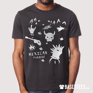 May include: A black t-shirt with a silver graphic print of a skull, guitar, stars, and the words "Mexican Funeral".