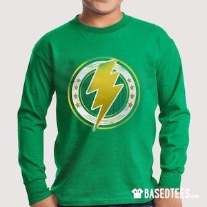 Puede incluir: Una camiseta de manga larga verde con un gráfico de rayo amarillo dentro de un círculo con estrellas doradas y un fondo verde y blanco.