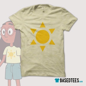 May include: A beige t-shirt with a yellow sun graphic. The sun is surrounded by six yellow triangles.