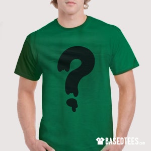 Puede incluir: Una camiseta verde con un gráfico de un signo de interrogación negro que gotea.