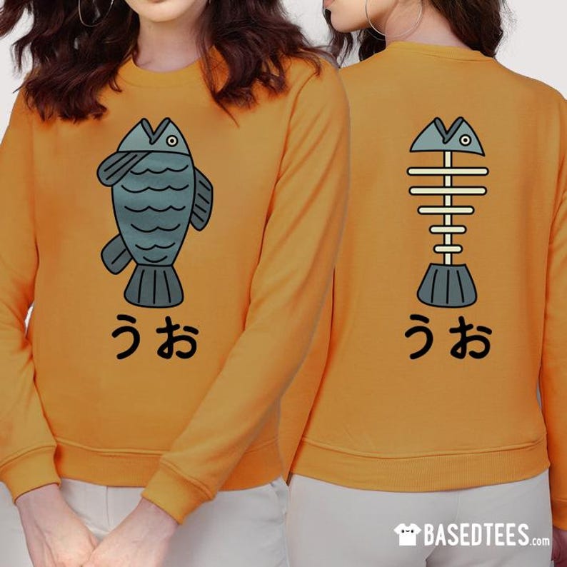 May include: A yellow sweatshirt with a cartoon fish and skeleton fish graphic on the front and back. The text "うお" is printed below each fish.