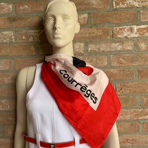 Puede incluir: Maniqu&iacute; con un vestido blanco, un cintur&oacute;n rojo y un pa&ntilde;uelo de seda. El pa&ntilde;uelo es rojo, negro y blanco con la palabra "Courr&egrave;ges" impresa. El cintur&oacute;n es rojo con una hebilla plateada.