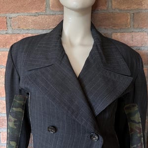 May include: A set of three ceramic mugs with a speckled, matte finish. The mugs are in shades of cream, light gray, and dark gray. Each mug has a simple, modern design and a rounded handle.