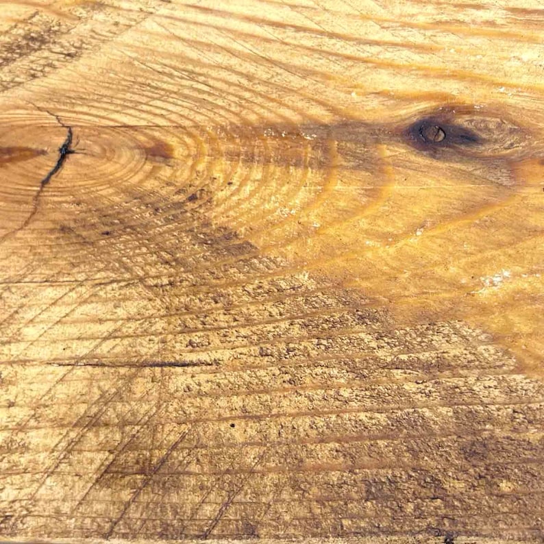 Op de afbeelding: Close-up van een lichtbruin houten oppervlak met een knoop en nerfpatronen. Het hout heeft een natuurlijke, rustieke uitstraling.