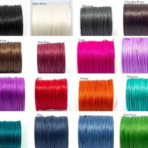 May include: A collection of spools of waxed cotton cord in various colours, including black, white, brown, red, orange, purple, teal, blue, green, and pink.