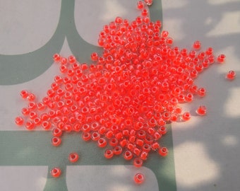 Toho - Seed Beads 11/0 GLASPERLEN  crystal / neon orange - lined