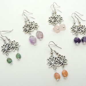 May include: Four pairs of silver lotus flower dangle earrings with different colored gemstone beads. The earrings feature a silver lotus flower charm with a dangling gemstone bead. The gemstones are amethyst, rose quartz, turquoise, and carnelian.