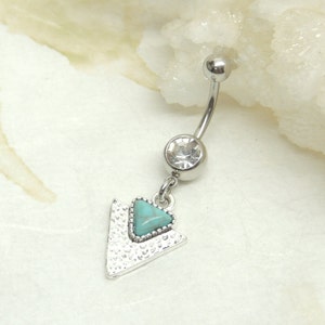 May include: Silver belly button ring with a turquoise triangle charm and a clear crystal.
