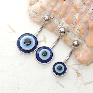 May include: Three silver belly button rings with blue evil eye charms. The charms are different sizes and have a white ring around the blue eye.