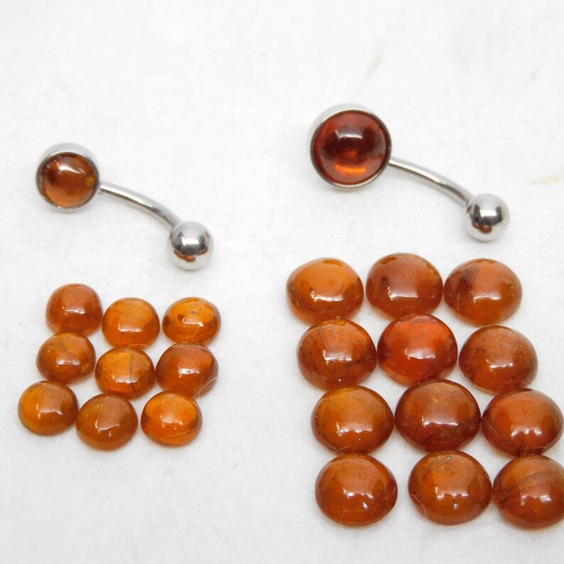 Puede incluir: Dos anillos de ombligo con piedras de color &aacute;mbar. Un conjunto de 16 piedras de color &aacute;mbar.