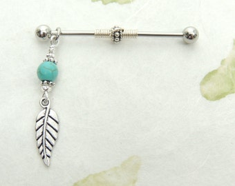 May include: Silver barbell with a turquoise bead and a silver feather charm. The barbell is a body piercing jewelry item.