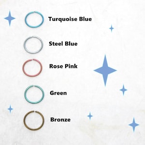 May include: A selection of five colored nose rings: turquoise blue, steel blue, rose pink, green, and bronze. Each ring is a simple, circular design. The colors are displayed with their names in a clean, white background with blue star accents.