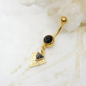May include: Gold belly button ring with a black gem and a dangling triangle charm with a black stone.
