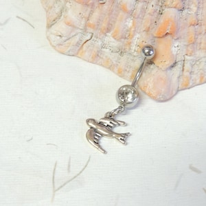 May include: Silver belly button ring with a clear crystal and a dangling silver bird charm.