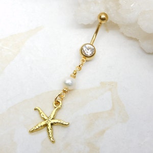 May include: Gold belly button ring with a clear crystal, a white pearl, and a gold starfish charm.