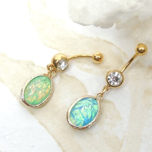 May include: Two gold belly button rings with clear crystal accents and oval-shaped green opal stones.