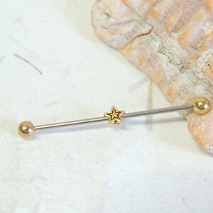 May include: A gold star barbell with two gold balls on either end. The barbell is made of surgical steel and is suitable for body piercing.