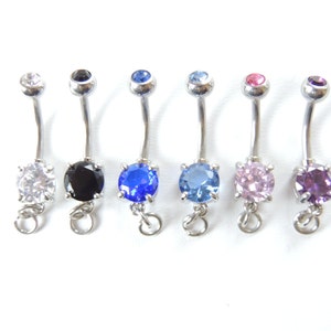 May include: Seven belly button rings with different colored gems. The gems are clear, black, blue, light blue, pink, and purple.